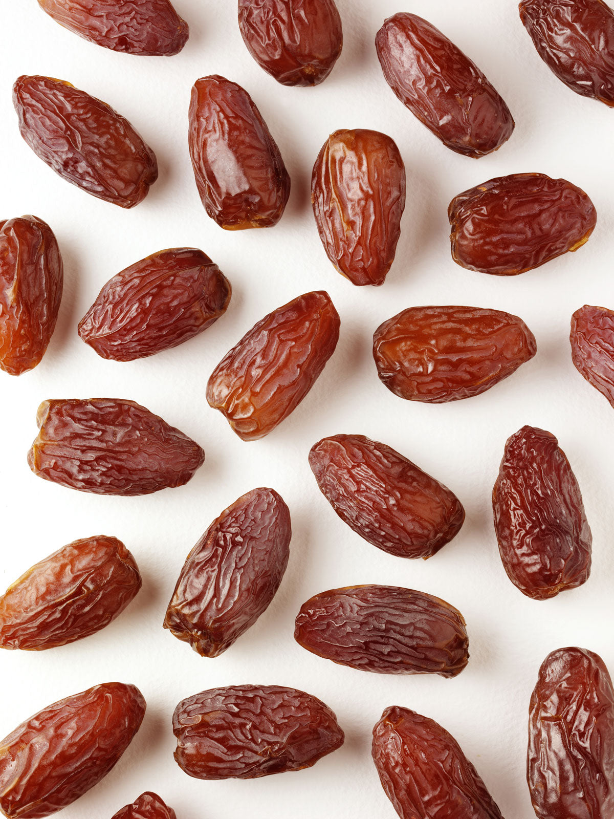 Medjool dates laid out on white background.